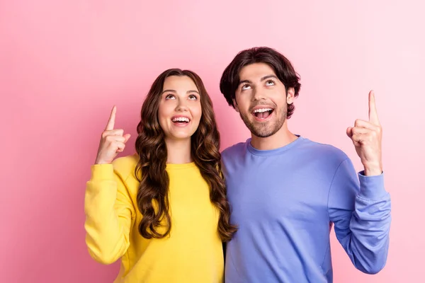 Fénykép a fiatal pár boldog pozitív mosoly megjelenés jelzi ujjak üres tér promo sugallják eladás elszigetelt rózsaszín szín háttér — Stock Fotó