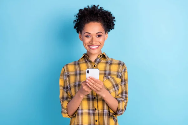 Foto retrato encaracolado mulher sorrindo usando telefone celular overjoyed isolado pastel azul cor de fundo — Fotografia de Stock