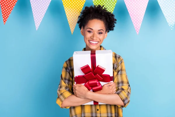 Genç siyah kızın fotoğrafı mutlu bir gülücük kucaklaşması mavi arka planda izole edilmiş hediye kutusuna sarılma — Stok fotoğraf