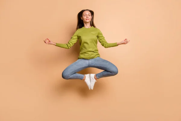 Longitud completa vista del tamaño del cuerpo de la chica bastante soñadora saltando meditando mostrando om signo aislado sobre fondo de color pastel beige —  Fotos de Stock