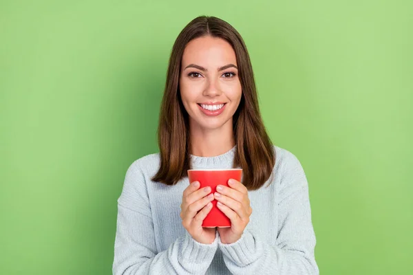 Fotografie optimistické mladé brunetky dáma pít kávu nosit modrý jumper izolované na zeleném pozadí — Stock fotografie