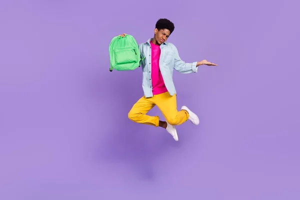 Fotografie zklamaný chlap skok držet batoh, aby výběr nosit modrou košili izolované fialové barvy pozadí — Stock fotografie