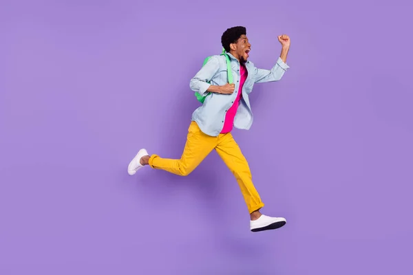 Foto de perfil de chico asombrado salto grito meta desgaste mochila camisa azul aislado violeta color fondo —  Fotos de Stock