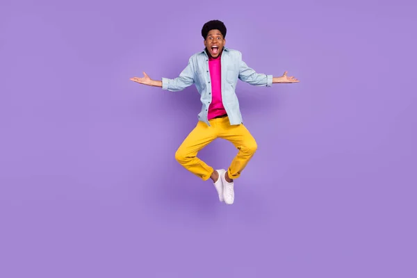 Foto de chico divertido despreocupado saltar levantar las manos fin de semana tiempo libre usar camisa azul aislado color púrpura fondo — Foto de Stock