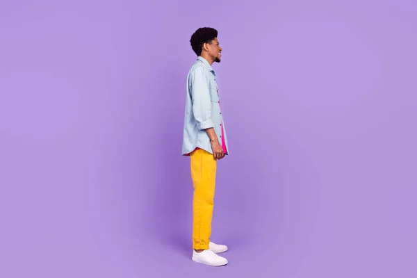 Foto de bonito adorável pele escura cara vestido camisa jeans olhando espaço vazio sorrindo isolado cor violeta fundo — Fotografia de Stock