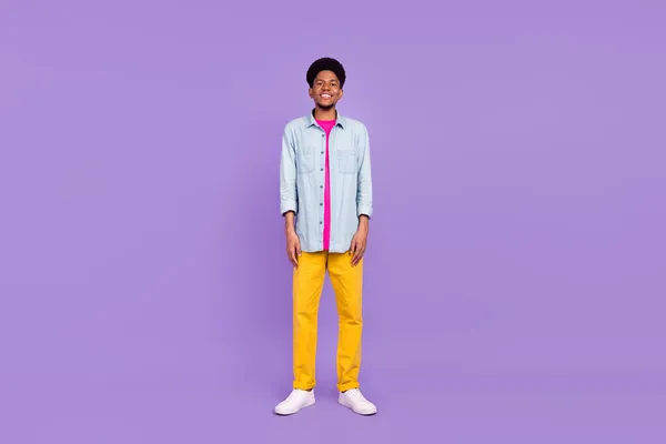 Foto de encantador divertido hombre de piel oscura usar camisa de mezclilla sonriendo aislado color púrpura fondo — Foto de Stock