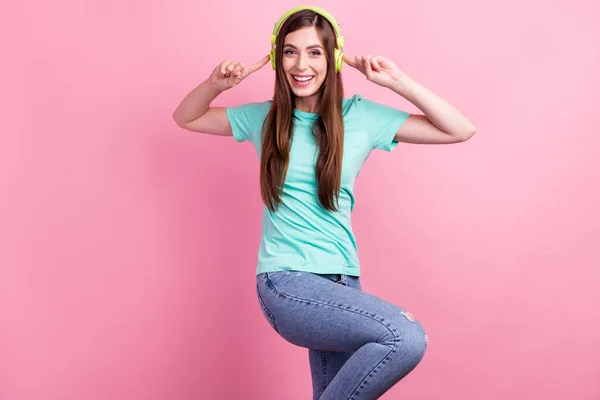 Foto di eccitata divertente giovane donna vestito turchese t-shirt puntando auricolari ascoltare musica sorridente isolato colore rosa sfondo — Foto Stock