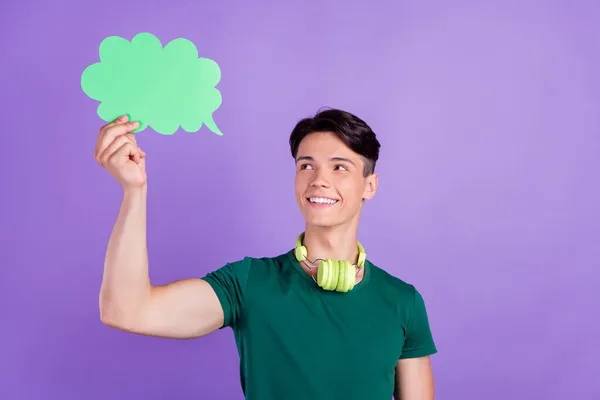 Foto von verträumt gesinnten positiven jungen Mann halten Wolke Rede Kopfhörer isoliert auf violettem Hintergrund — Stockfoto