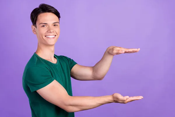 Zdjęcie wesołego młodego szczęśliwego pozytywnego człowieka trzymać za ręce pusty rozmiar przestrzeni odizolowany na fioletowym tle koloru — Zdjęcie stockowe