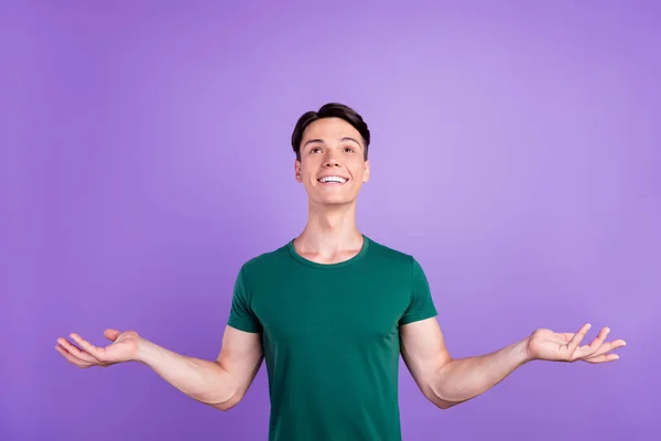 Foto van vrolijke positieve jonge man verhogen handen lege ruimte op te zoeken genieten geïsoleerd op violette kleur achtergrond — Stockfoto