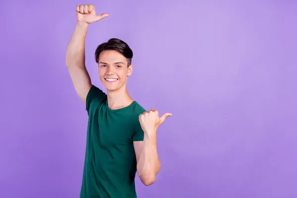 Foto di allegro giovane uomo felice punta il dito vuoto spazio vendita notizie isolato su sfondo di colore viola — Foto Stock