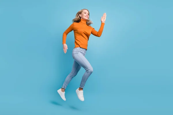 Foto de cuerpo completo de la mujer positiva bastante agradable saltar correr vacío espacio sonrisa aislado en el fondo de color azul —  Fotos de Stock