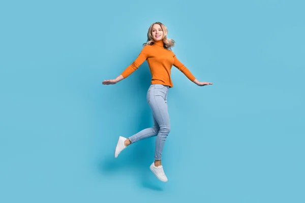 Foto de comprimento total de alegre jovem mulher olhar espaço vazio saltar para cima do ar isolado no fundo cor azul pastel — Fotografia de Stock