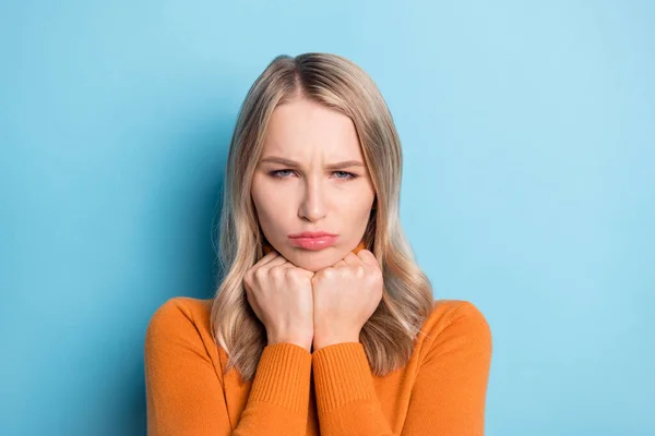 Photo of sad unhappy young lady wear orange sweater arms chin isolated blue color background — Stock Photo, Image