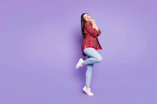 Lunghezza completa foto di dolce bruna acconciatura giovane signora tenere le mani indossare jeans camicia rossa isolato su sfondo di colore viola — Foto Stock