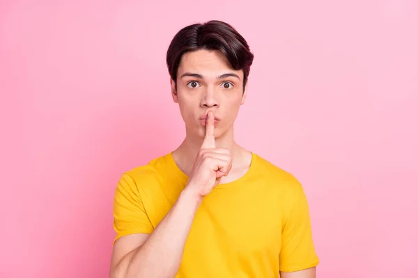 Foto van ernstige zelfverzekerde jongeman dragen gele t-shirt vinger mond vragen niet vertellen geheimen geïsoleerde roze kleur achtergrond — Stockfoto