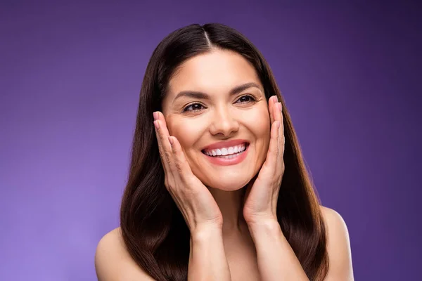 Foto von attraktiven reifen glückliche Frau halten Hände Gesicht Anti-Age-Creme gelten isoliert auf Farbverlauf violetten Hintergrund — Stockfoto