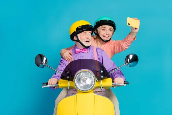 Foto van grijs haar gepensioneerde gepensioneerde echtgenoot vrouw paar mensen dragen helm rider maken selfie geïsoleerd op blauwe kleur achtergrond — Stockfoto