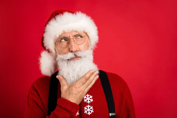 Çekici düşünceli şüpheli Noel Baba 'nın portresi. Parlak kırmızı arka planda izole edilmiş bir fotokopi alanı reklamı. — Stok fotoğraf