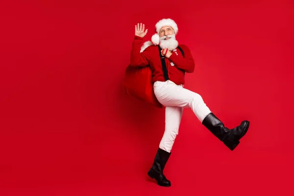 Full length body size view of nice cheerful Santa carrying giftboxes waving hi hello isolated over bright red color background — Stock Photo, Image