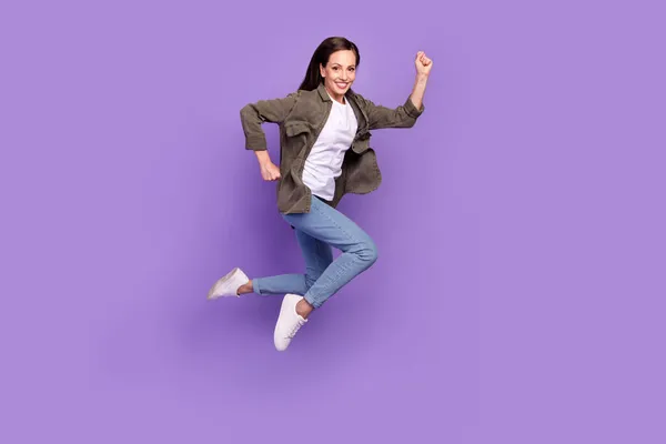 Longitud completa tamaño del cuerpo foto sonriente mujer saltando alto corriendo en venta aislado pastel púrpura color de fondo — Foto de Stock