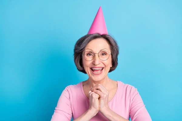 Fénykép boldog izgatott vidám érett nő fogja kezét várakozás kopás kúp kalap elszigetelt kék színű háttér — Stock Fotó