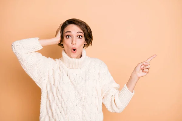 Photo of amazed shocked young lady hold hand head unbelievable news point finger empty space isolated on beige color background — Stock Photo, Image