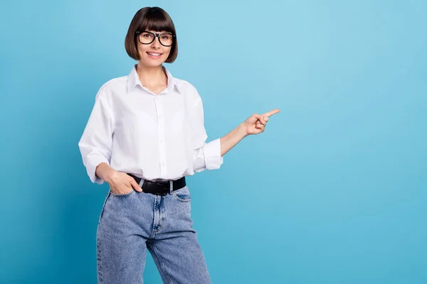 Retrato de chica alegre atractiva demostrando espacio de copia lugar anuncio como seguir aislado sobre fondo de color azul brillante —  Fotos de Stock