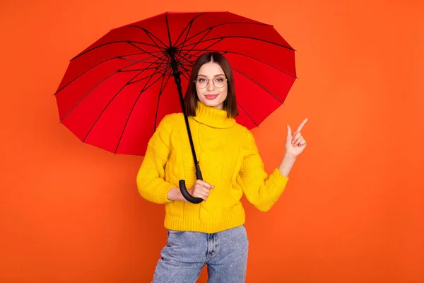 Φωτογραφία της νεαρής γυναίκας ευτυχής θετικό χαμόγελο σημείο δάχτυλο κενό χώρο διαφημίσεις ομπρέλα επιλογή απομονωμένη πάνω από πορτοκαλί χρώμα φόντο — Φωτογραφία Αρχείου