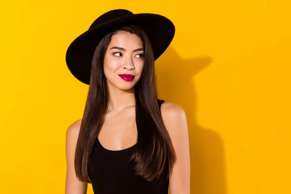 Φωτογραφία από γοητευτικό ονειρική νεαρή ασιατική γυναίκα ματιά emoty χώρο φορούν μαύρο καπέλο απομονώνονται σε κίτρινο χρώμα φόντο — Φωτογραφία Αρχείου