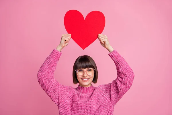 Foto de jovem positivo mulher muito feliz segurar as mãos forma do coração acima da cabeça isolado no fundo cor-de-rosa — Fotografia de Stock