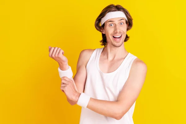 Porträtt av attraktiva glada funky sportig kille fastställande armband pilates isolerad över ljusa gula färg bakgrund — Stockfoto