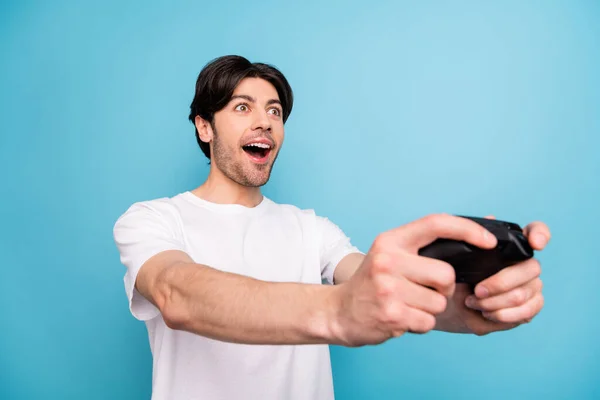 Portret van aantrekkelijke verbaasd vrolijke jongen spelen video game plezier geïsoleerd over levendige blauwe kleur achtergrond — Stockfoto