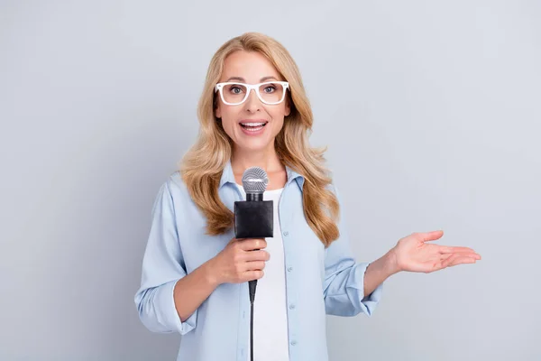 Bild av populärt korrespondent hålla mikrofon tala berätta nyheter bära specs blå skjorta isolerad grå färg bakgrund — Stockfoto