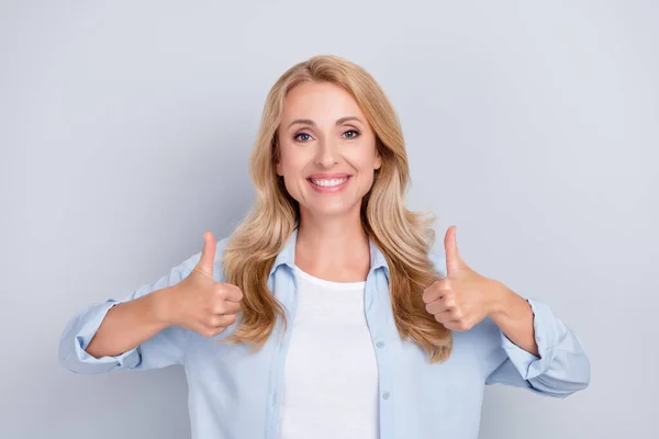 Foto de boa senhora positiva levantar dois polegares concordam sorriso usar camisa azul isolado fundo cor cinza — Fotografia de Stock