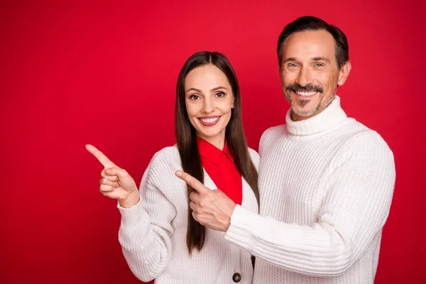 Foto von fröhlichen glücklichen Mann und Frau Ehemann Frau Paar Zeigefinger leeren Raum Lächeln isoliert auf rotem Hintergrund — Stockfoto