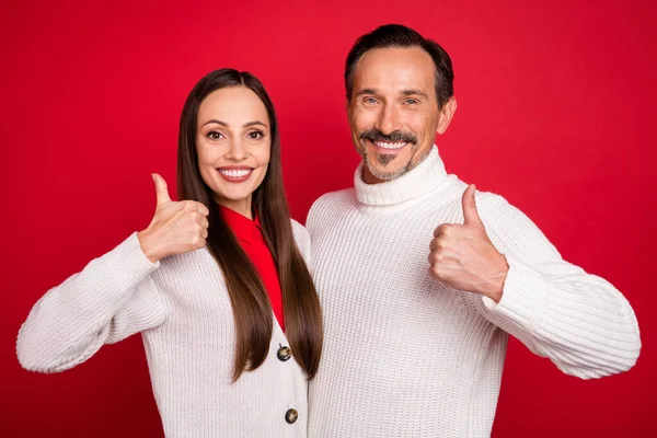Photo de couple heureux homme et femme faire pouce vers le haut profiter signe sourire isolé sur fond de couleur rouge — Photo