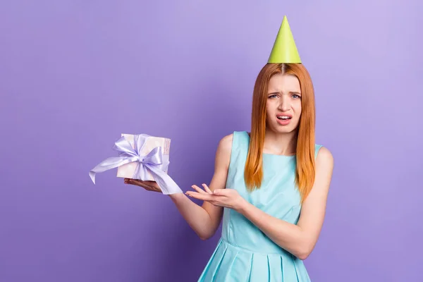 Fotografie mladé dívky nešťastné nerad držet dárek box narozeninová párty izolované přes fialové barvy pozadí — Stock fotografie