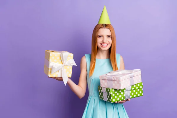 Фото очаровательной счастливой привлекательной молодой леди держатся за руки подарки день рождения изолирован на фиолетовом фоне цвета — стоковое фото
