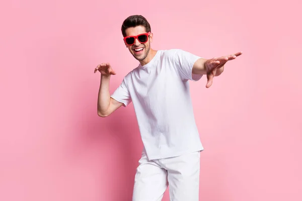 Ritratto di attraente funky allegro ragazzo che balla divertendosi buon umore riposo isolato su sfondo rosa pastello — Foto Stock