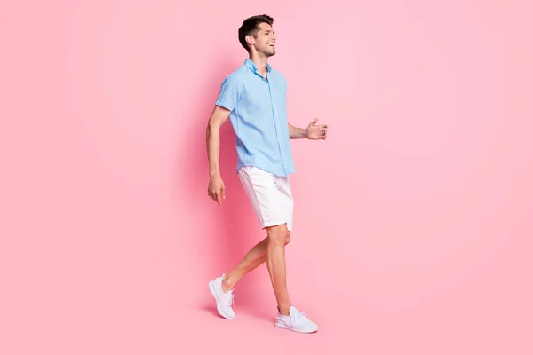 Profil zdjęcie pozytywne wesoły facet cieszyć promenada nosić niebieskie szorty trampki izolowane na różowy kolor tła — Zdjęcie stockowe