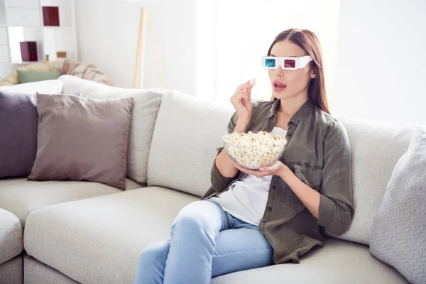 Фото очаровательной потрясенной молодой женщины, одетой в хаки рубашку 3d очки едят попкорн смотреть страшное кино в помещении домашней комнаты — стоковое фото