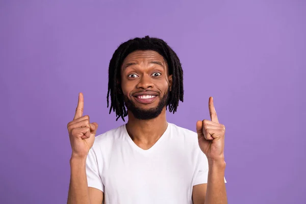 Фото изумленного шокированного афро-американского молодого человека указывать пальцем вверх раствор изолирован на фиолетовом фоне цвета — стоковое фото