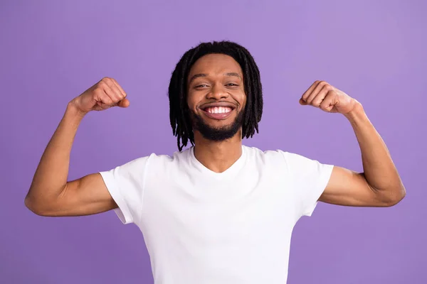 Retrato de cara forte alegre atraente demonstrando músculos poderosos isolados sobre fundo de cor roxo violeta brilhante — Fotografia de Stock
