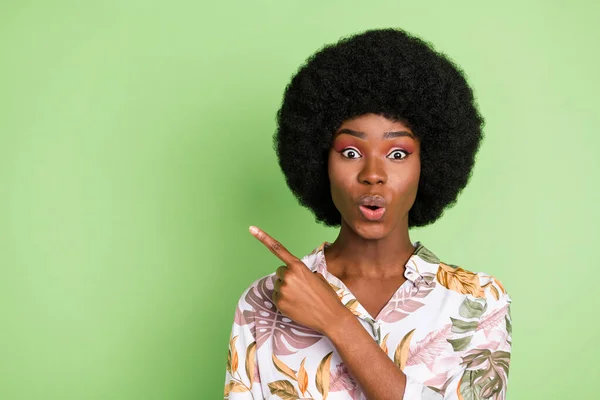 Fénykép a fiatal fekete lány boldog pozitív mosoly jelzi ujj üres hely azt sugallják, válassza eladó hirdetés elszigetelt zöld színű háttér — Stock Fotó