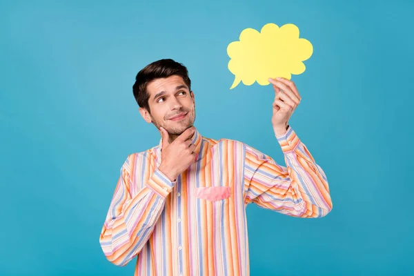Photo of young happy minded thoughtful man hold hand speech bubble minded isolated on blue color background