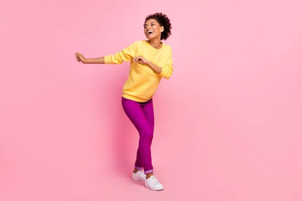 Foto de encantadora mujer brillante vestida suéter amarillo sonriente bailando aislado color rosa fondo —  Fotos de Stock