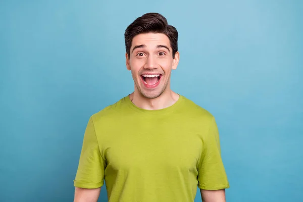 Фото фанк молодого брюнетки хлопець носить зелену футболку ізольовано на синьому кольорі — стокове фото