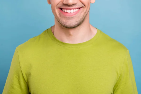Zdjęcie pozytywnego wesołego młodego faceta ubranego na zielono t-shirt pokazujący zęby uśmiechnięte odizolowany niebieski kolor tła — Zdjęcie stockowe