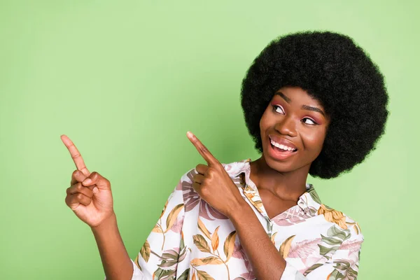 Foto de joven negro chica feliz sonrisa positiva punta dedos espacio vacío recomendar promo aislado sobre fondo de color verde — Foto de Stock